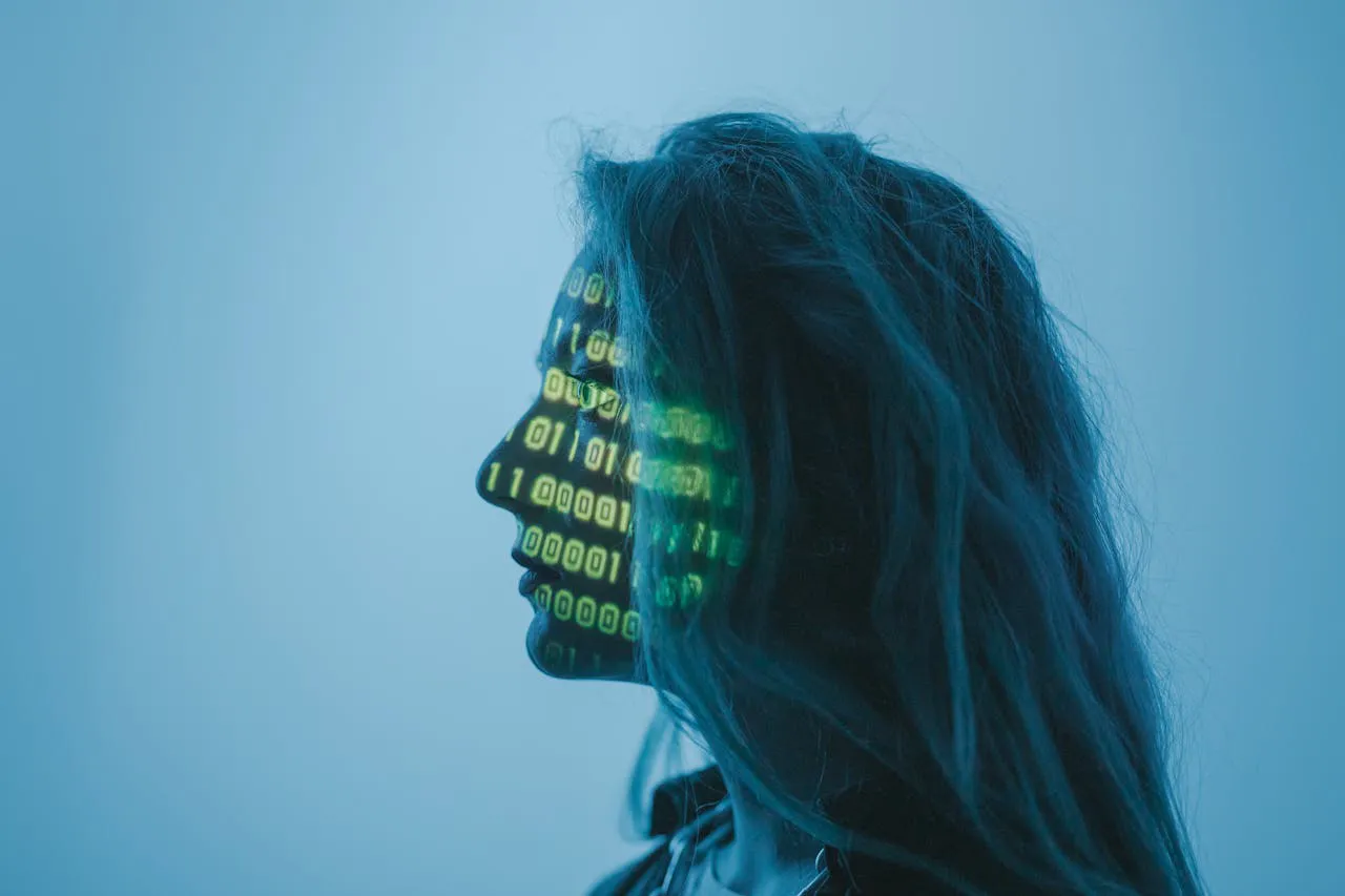 Silhouet van een persoon met een groene binaire code op hun gezicht, afgebeeld tegen een blauwe achtergrond.