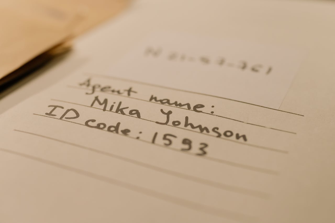 Notitieblad met de naam en ID-code van een agent, geschreven in handschrift.